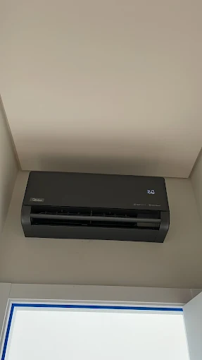 Ar-condicionado split preto instalado acima de uma janela